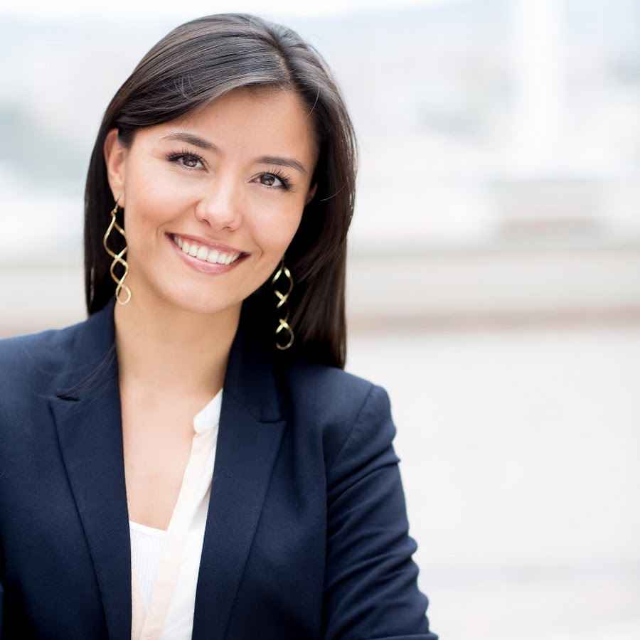 Photo de Marie Dubois, une astrologue expérimentée avec de longs cheveux bruns et des lunettes, souriant chaleureusement à la caméra